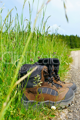 Nahaufnahme von Wanderstiefeln am Straßenrand