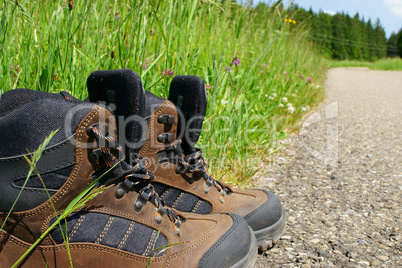 Nahaufnahme von Wanderschuhen am Straßenrand