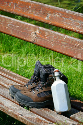 Wanderstiefel und Feldflasche auf einer Bank