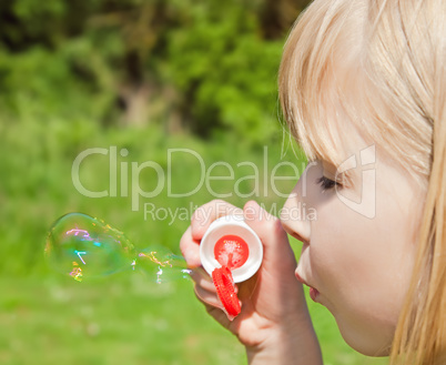 child blowing soap bubbles
