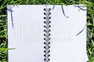 Blank Note Book in Fresh Green Grass Background