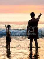 Vater und Sohn vor Abendhimmel am Meer