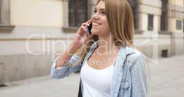 Young Woman with Phone Walking at the Street