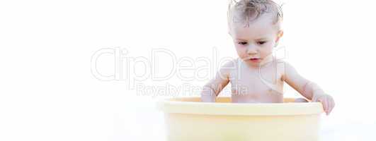 Baby Sitting in a Yellow Bath Basin Against White