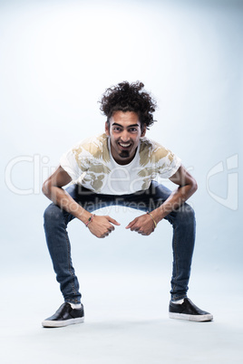 Smiling Hip Hop Dancer Squatting with Arm on Knees