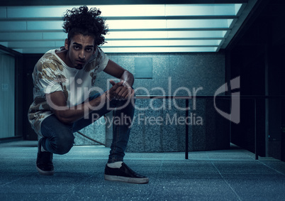 Curly-Haired Young Guy Squatting Inside a Building