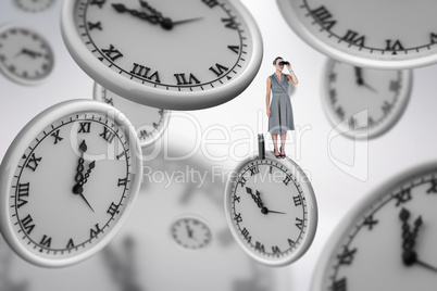 Composite image of a businesswoman looking through binoculars