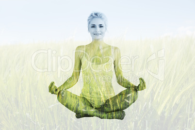 Composite image of toned young woman sitting in lotus pose