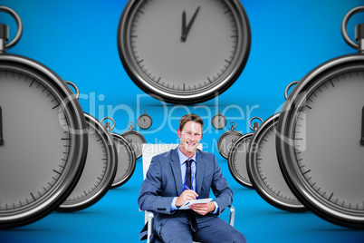 Composite image of businessman writing down on a notebook