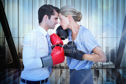 Composite image of business people wearing and boxing red gloves