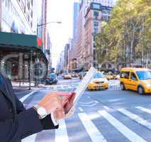Composite image of businessman in suit using digital tablet