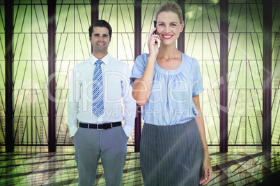Composite image of businesswoman having phone call while her col