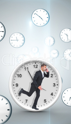 Composite image of businessman running on the phone