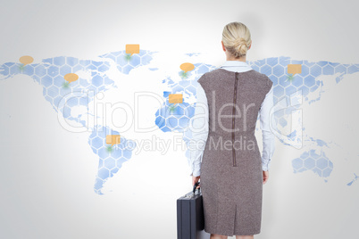 Composite image of back turned businesswoman holding a briefcase