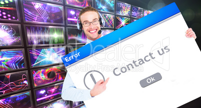 Composite image of businessman showing card wearing headset