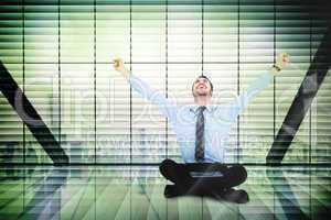 Composite image of businessman cheering with tablet sitting on f