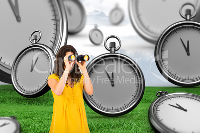 Composite image of casual young woman using binoculars