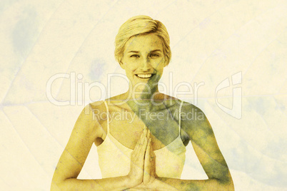 Composite image of happy woman doing yoga smiling at camera