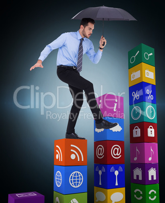 Composite image of focused businessman holding umbrella and bala