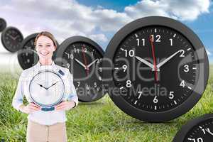 Composite image of businesswoman in suit holding a clock