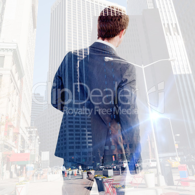 Composite image of businessman standing and looking