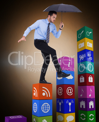Composite image of focused businessman holding umbrella and bala