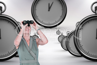 Composite image of a businesswoman looking through binoculars