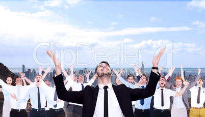 Composite image of businessman cheering with hands raised