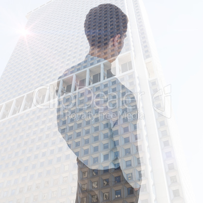 Composite image of businessman standing with hands in pockets