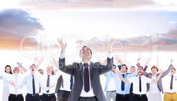 Composite image of happy businessman with arms raised