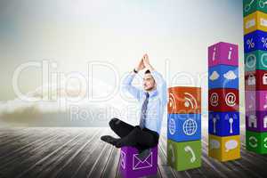 Composite image of calm businessman sitting in lotus pose with h