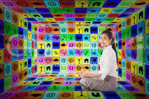 Composite image of businesswoman sitting in lotus pose