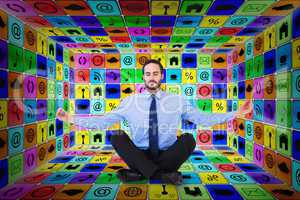 Composite image of businessman in suit sitting in lotus pose