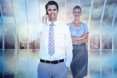 Composite image of businessman having phone call while his colle