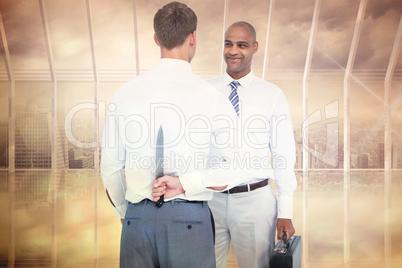 Composite image of businessman holding knife behind his back
