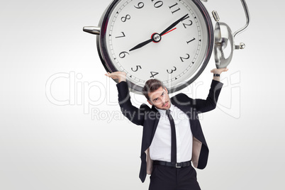 Composite image of businessman in suit lifting up something heav