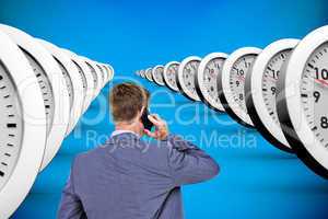 Composite image of back turned businessman on the phone