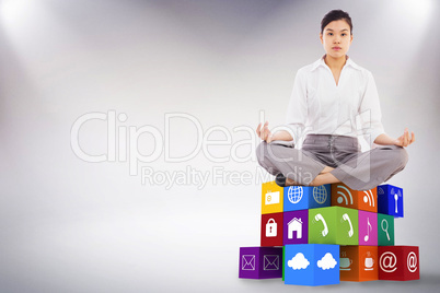 Composite image of businesswoman sitting in lotus pose