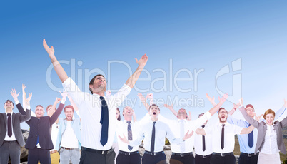 Composite image of handsome businessman cheering with arms up