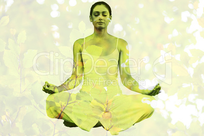 Composite image of peaceful woman in white sitting in lotus pose