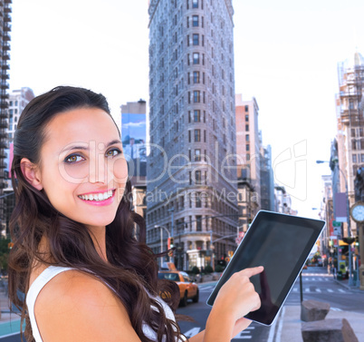 Composite image of pretty brunette using tablet pc