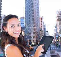 Composite image of pretty brunette using tablet pc