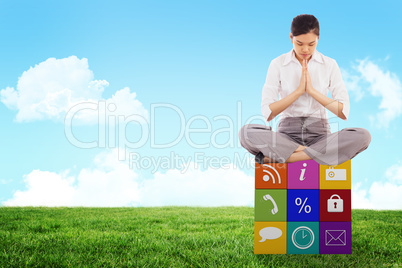 Composite image of businesswoman sitting in lotus pose