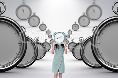 Composite image of businesswoman holding clock