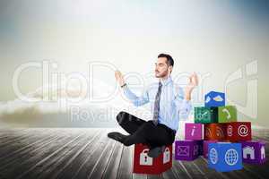 Composite image of relaxed businessman sitting in lotus pose