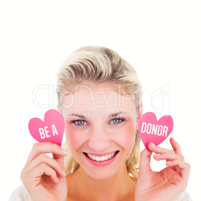 Composite image of attractive young blonde holding little hearts