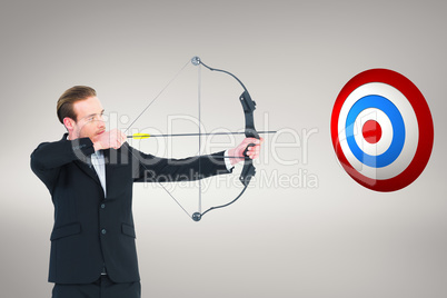 Composite image of businessman shooting a bow and arrow Composite image of businessman shooting a bow and arrow