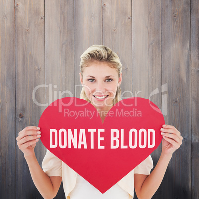 Composite image of attractive young blonde showing red heart