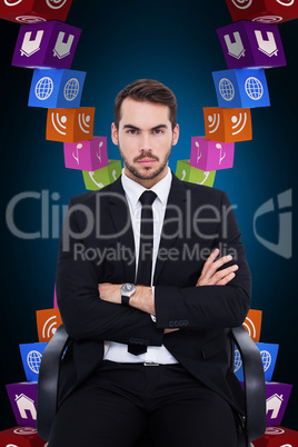 Composite image of serious businessman sitting with arms crossed