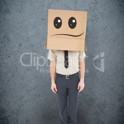 Composite image of businessman standing with box on head